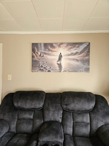 Reviewer's beautiful Walking on Water wall art hanging on a living room wall above a dark sofa.
