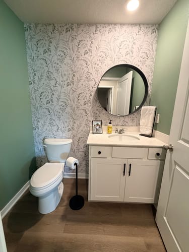 Customer's bathroom with Winsome Wallpaper on an accent wall behind the vanity and toilet.