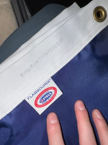 Close-up: Reviewer's hand holds the flag's white header, showing the 'Made in U.S.A.' certification tag.