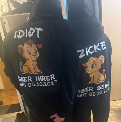Rezensenten zeigen die Rückseite ihrer passenden schwarzen Löwenpärchen-Hoodies mit personalisiertem Aufdruck.
