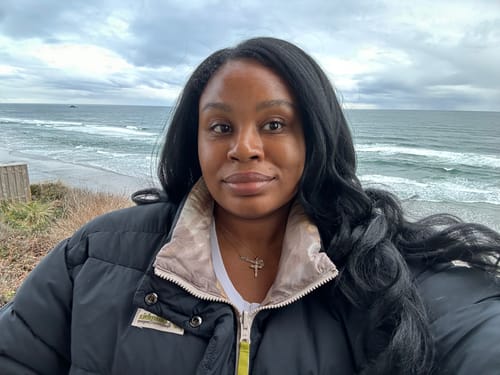 A reviewer wears the long, curly Sensationnel LARISSA wig outdoors.