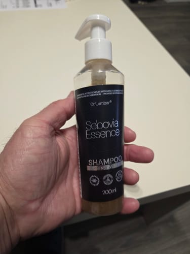 Értékelő kezében tartja a Seboria Essence sampon pumpás flakonját.