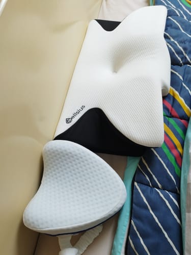 Le coussin d'alignement cervical Cellsius d'un client, blanc et noir, posé sur un lit.