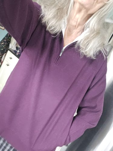 Reviewer wearing the purple Quinn Ribbed 1/4 Zip over a white collared shirt with her hand in the pocket.