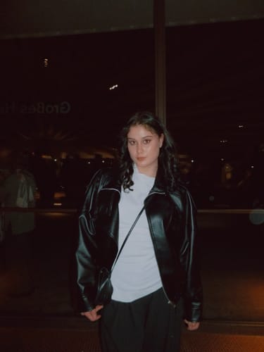 Reviewer wearing the black Carla Asymmetrical Leather Jacket, showing its stylish oversized fit.