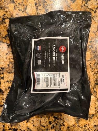 Customer's USDA Prime Chuck Roast in its black vacuum-sealed packaging on a granite countertop.