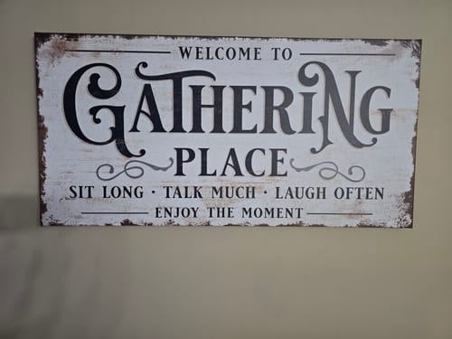 Customer's rustic Gathering Place Personalized Sign with black text hanging on a wall.