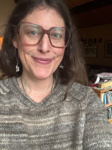 Reviewer smiling in a close-up, wearing the cool-toned tinted La La Lips lip balm.