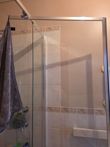 Reviewer's glass shower door, which is clean and streak-free after using the KoalaCloth Essentials Bundle.