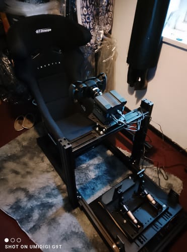 Customer's MOZA R9 V3 Wheel Base shown attached to a complete, black racing simulator cockpit.