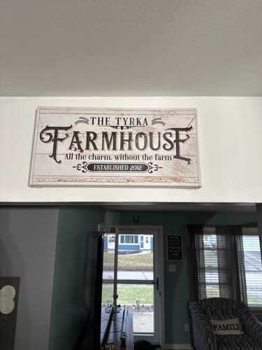 Customer's Personalized Farmhouse Sign II with the name 'Tyrka' hanging on a white wall in their home.