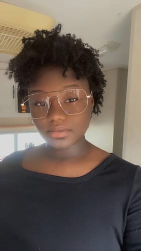 Reviewer looking at the camera, showing a short hairstyle using the dark Zury Sis V11 Mini Twist braids.