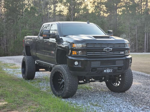 Customer's blackout metal license plate with 'MENACE' text, mounted on a large black truck.