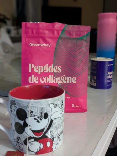 Photo d'un client montrant le sachet rose de Peptides de Collagène à côté d'une tasse de thé.