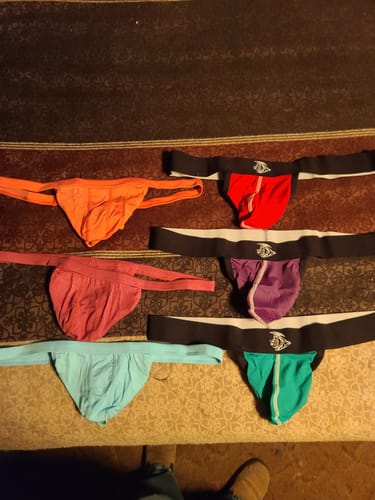 Customer's collection of colorful Modal thongs in traditional and strapless styles laid out on a surface.
