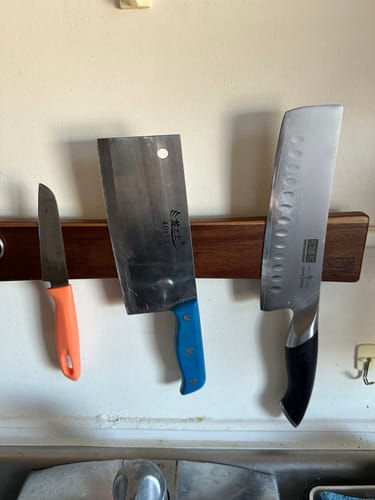 Customer's Japanese Nakiri knife on a magnetic wooden strip next to two other knives.