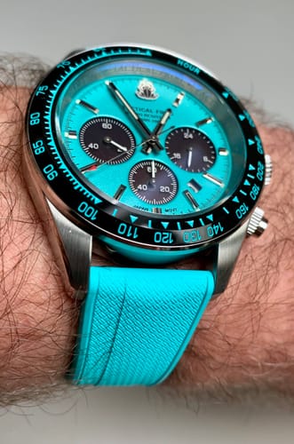 Reviewer's close-up of the vibrant turquoise Shark Skin Rubber strap on their watch.