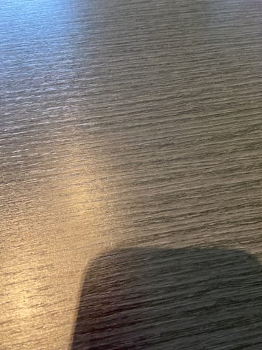 Rezensent zeigt eine Nahaufnahme einer dunklen, strukturierten Oberfläche.