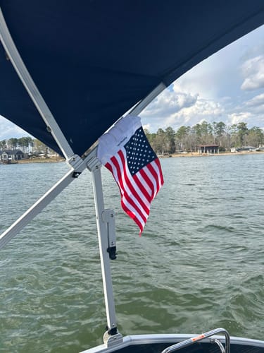 Customer's American Flag attached to a boat canopy frame over a lake.