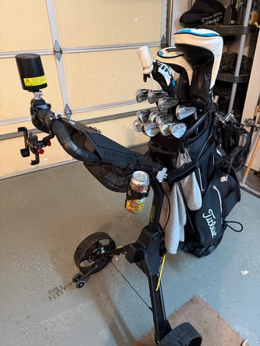 Reviewer's black Cybercart + Sidekick shown fully assembled in a garage with a golf bag and accessories attached.
