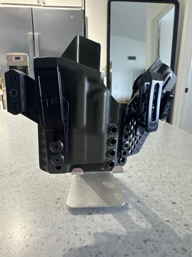 Reviewer's black APX holster with its modular magazine carrier displayed on a countertop.