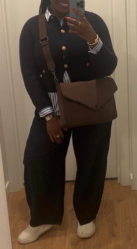 Reviewer taking a mirror selfie showing their brown Essential Envelope bag worn crossbody with a work outfit.