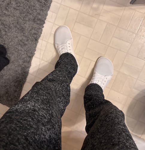 Customer's view looking down at their new white shoes, highlighting the wide toe box.