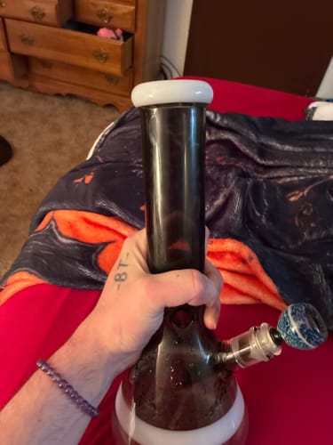 Reviewer holding their dark glass Beaker Water Pipe filled with smoke, using their own custom bowl.
