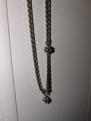 Close-up of a customer's silver Spikeball Choker hanging, showing the chain and sharp spiky charms.