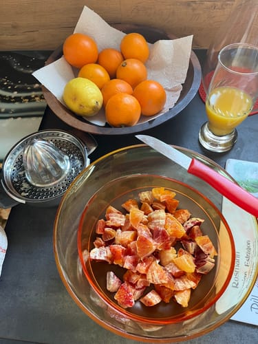 Ein Kunde zeigt die vielseitigen Mini-Orangen als ganze Früchte, als Saft und in einem bunten Obstsalat.