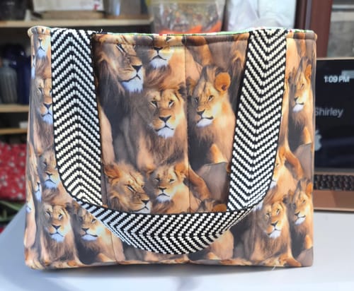 Reviewer's finished tote bag made from the Packed Realistic Lions Pattern fabric, with black and white chevron straps.