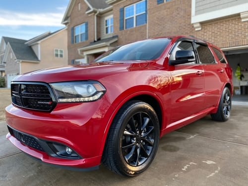 Customer's shiny red SUV parked in a driveway after being detailed with a Blackline product.