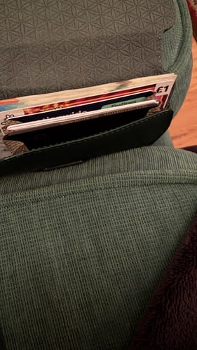 Customer's open green wallet showing the SPOTMINDERS Tracking Card hidden among cash and other cards.