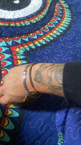 Primer plano de la Pulsera Miami Cuban en la muñeca tatuada de un cliente.