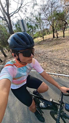 Reviewer wearing the colorful MOMENTUM JERSEY and black shorts while riding a bike outdoors.