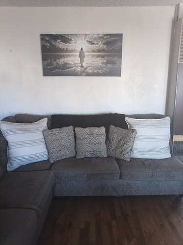 Customer's Walking on Water - Faith Wall Art III canvas displayed on a living room wall above a grey sofa.
