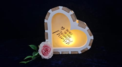 Kundenbewertung: Ein beleuchteter Herzrahmen aus der Silikonform mit einer Aufschrift. Daneben liegt eine einzelne rosa Rose.