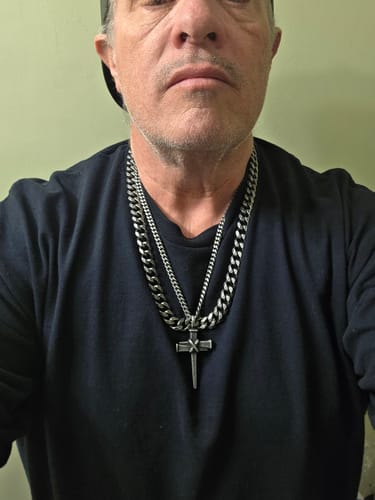 Reviewer wearing the Nailed to the Cross necklace with a thick chain against a black shirt.