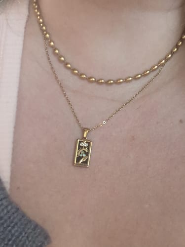Close-up of a reviewer wearing the gold Malaga Bead Necklace layered with another thin chain necklace.
