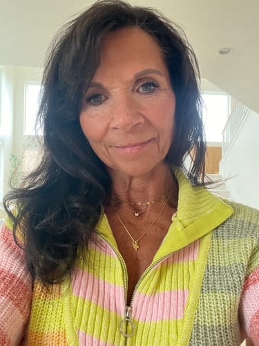 Reviewer wearing the gold Redeemed Necklace layered with another chain.