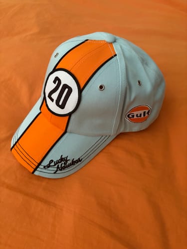 A customer's Gulf #20 baseball cap in light blue, showing its orange stripe, #20 patch, and embroidered bill.