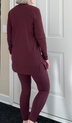 Reviewer from behind wearing the Evie Ribbed Tunic in toasted garnet, showing the garment's length and side slits.