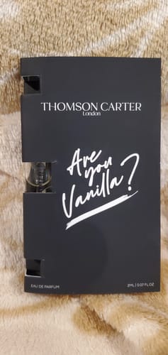 Customer's 2ml sample of Are You Vanilla Night Eau de Parfum in its black card packaging, resting on a textured surface.