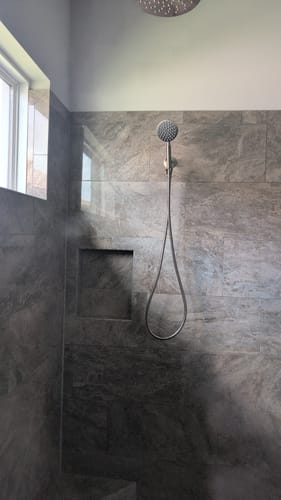 Customer's Handheld Shower Head Set installed on a gray tiled shower wall.