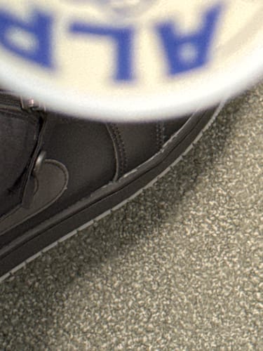 Close-up: A blurry partial view of a reviewer's can of ALP's Chilled Mint Nicotine Pouches.