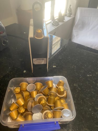 Customer's gold Blend 14 coffee pods in a storage container, with one pod in their coffee machine.