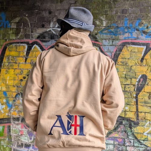 Reviewer from behind wearing a sand-colored College hoodie with a large custom logo printed on the lower back.