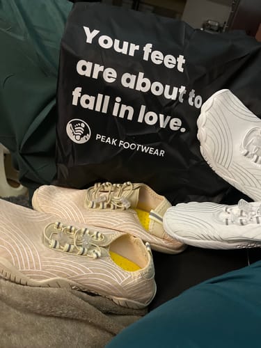 Customer's two pairs of Rift Motion barefoot shoes, one white and one beige, displayed with a branded bag.