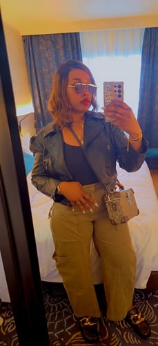 Reviewer taking a mirror selfie, styling the green Oversized Cargo Tapered Pants with a black jacket.