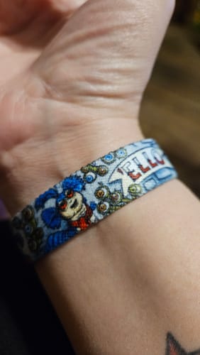 Customer's wrist wearing the Labyrinth Bracelet, featuring a close-up of the illustrated Worm character.